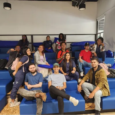 Grupo de terapeutas sonriendo sentados en una gradería azul durante una jornada de formación