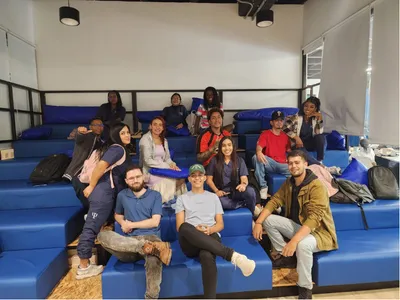 Grupo de personas sonriendo sentadas en gradas azules