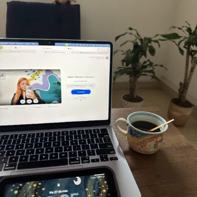 Computador portátil con una sesión de terapia en línea, una taza de café y una planta